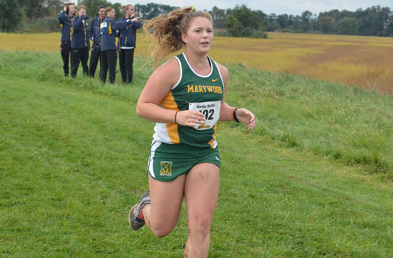 A female member of Marywood's track and field team running during a meet.